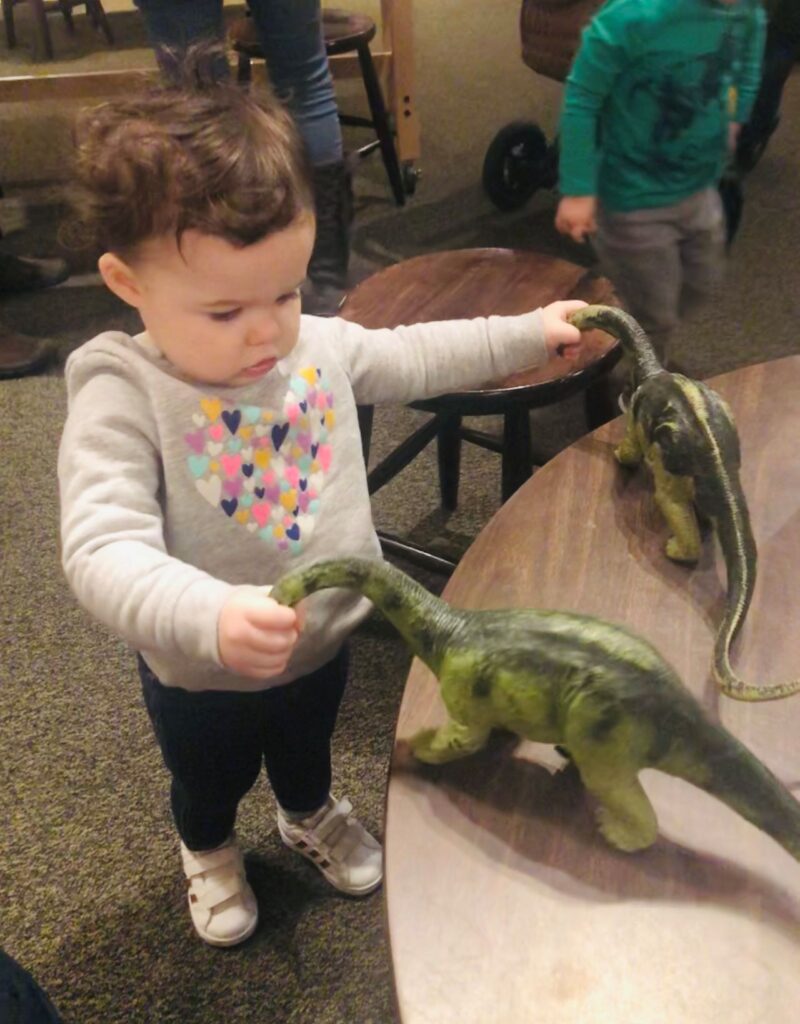 toddler girl with dinosaurs
